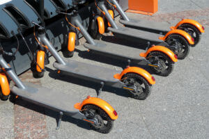 orange e-scooters in a rack