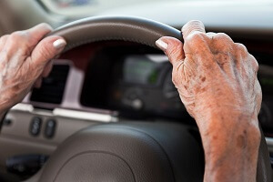 elderly woman hands on steering wheel