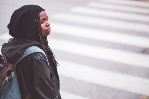 young woman standing at crosswalk