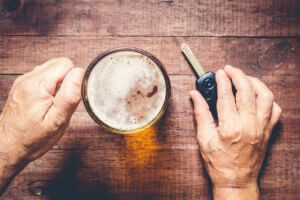 Hands holding a drink and car keys