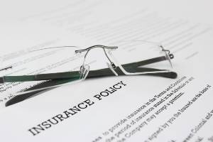 documents for insurance policy with glasses on top
